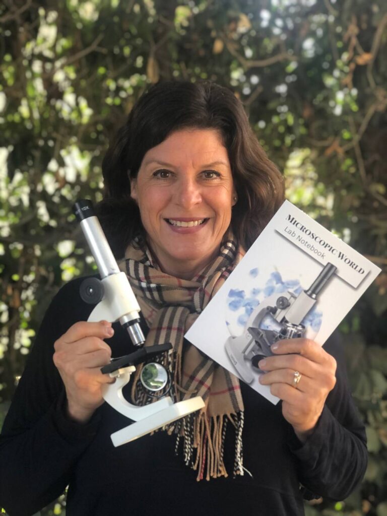 woman with microscope and science booklet
